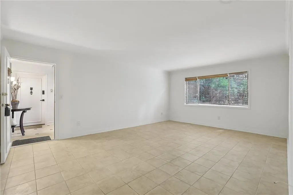 Empty room with light tile patterned flooring and baseboards