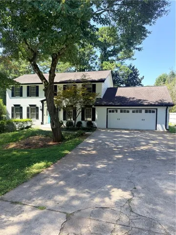 White exterior with black shutters and a two-car garage