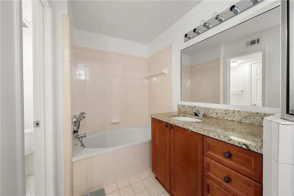 Full bathroom with tiled shower / bath, vanity, and light tile patterned flooring