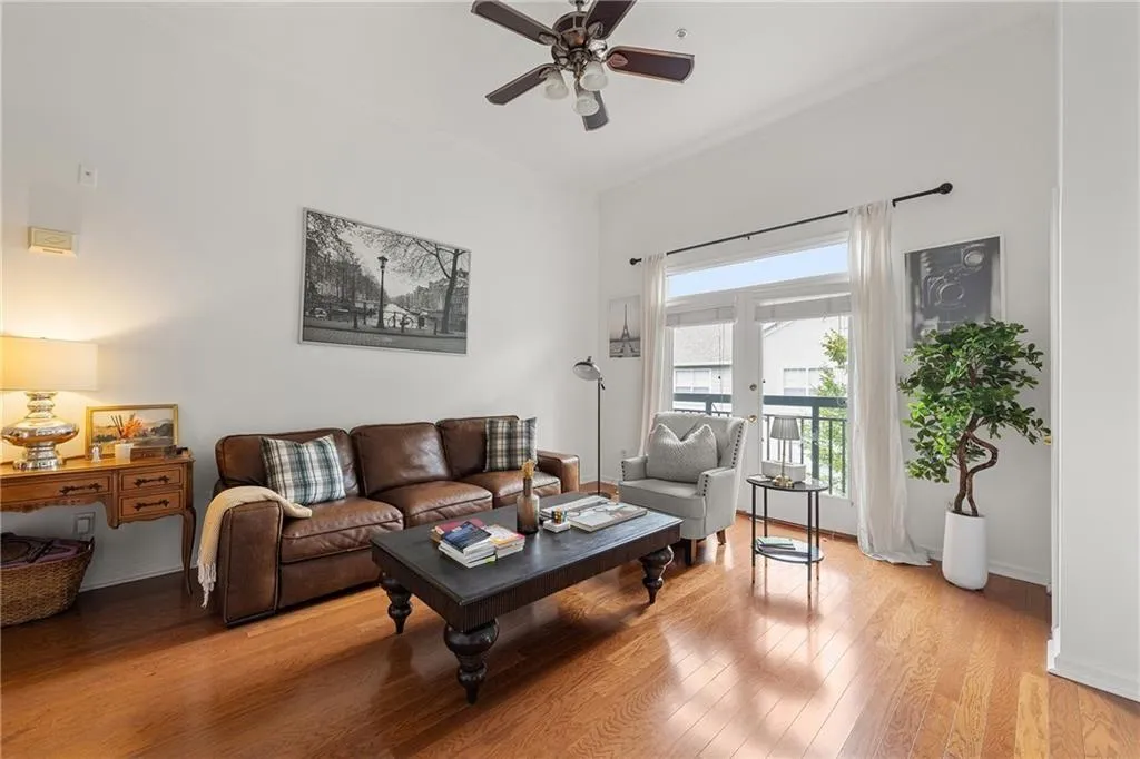 Living area with light wood finished floors and a ceiling fan