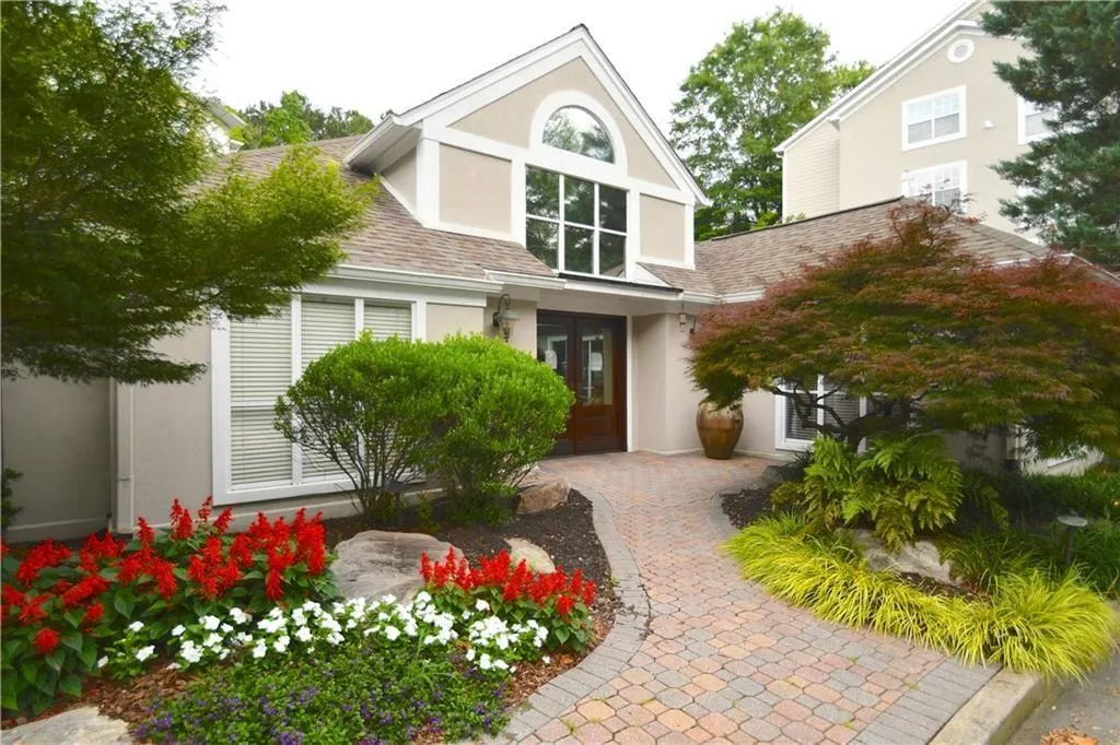 View of front of property featuring stucco siding, a shingled roof, and french doors