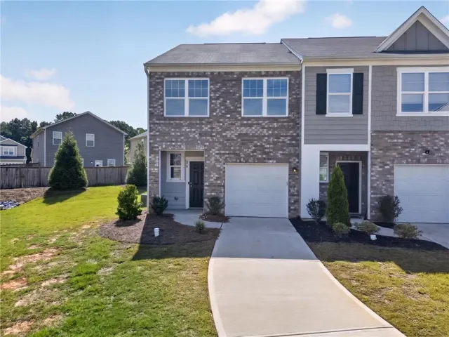 Brick and siding exterior with a single-car garage and a paved driveway