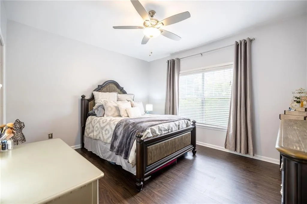 Bedroom featuring baseboards, dark wood-type flooring, and a ceiling fan