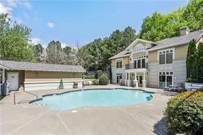 Outdoor pool featuring a patio and view of scattered trees