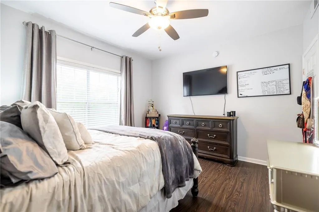Bedroom with dark wood-type flooring, baseboards, and ceiling fan