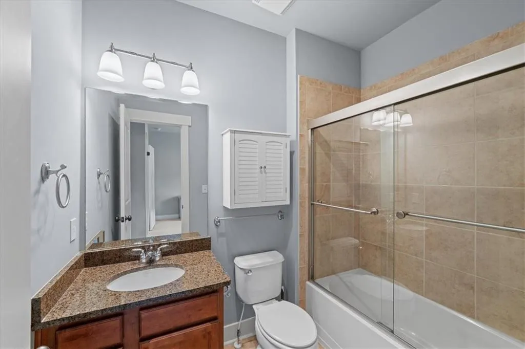 Bathroom with enclosed tub / shower combo and vanity