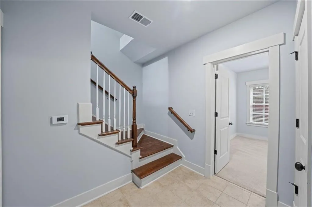 Staircase with carpet and tile patterned floors