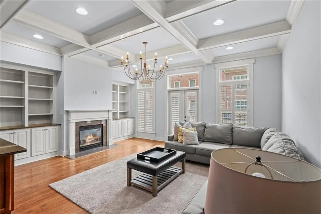 Living area featuring a high end fireplace, light wood-style floors, french doors, recessed lighting, and a chandelier