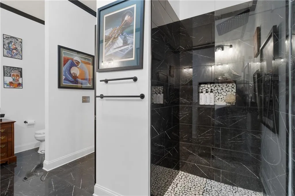 Full bathroom featuring vanity, a walk in shower, and marble finish floors