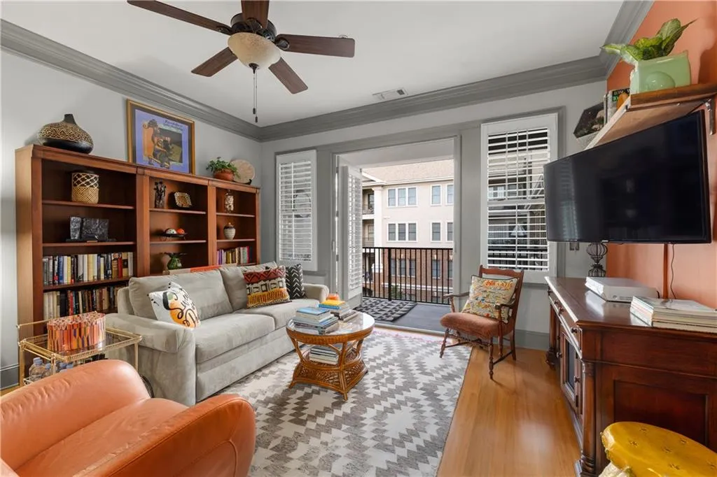 Living area featuring crown molding, light wood finished floors, and ceiling fan