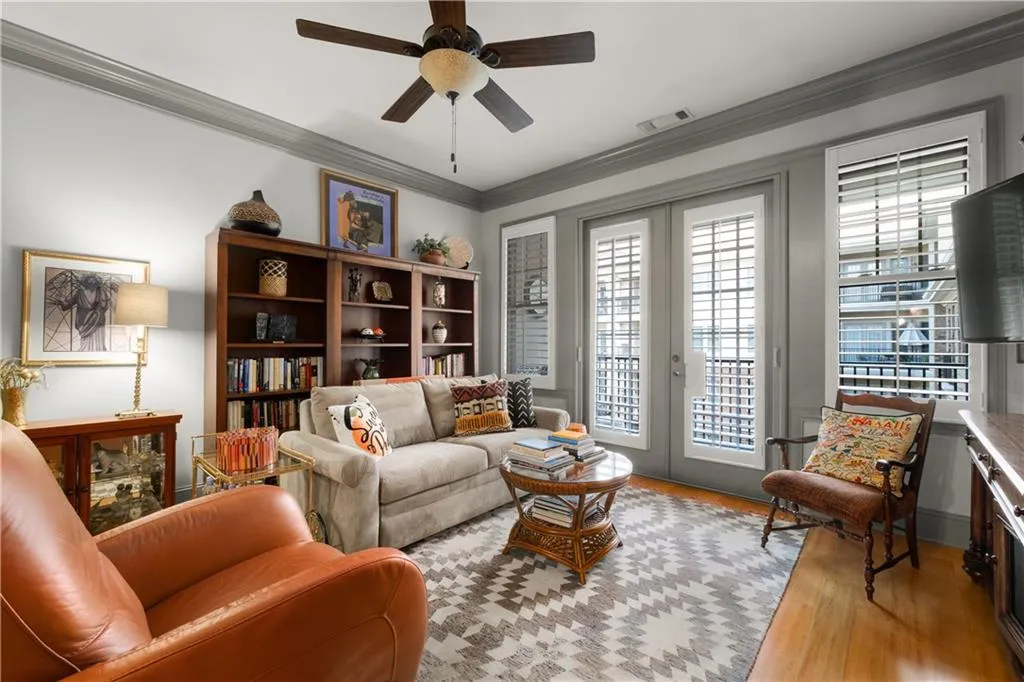Living area featuring ornamental molding, wood finished floors, a ceiling fan, and french doors