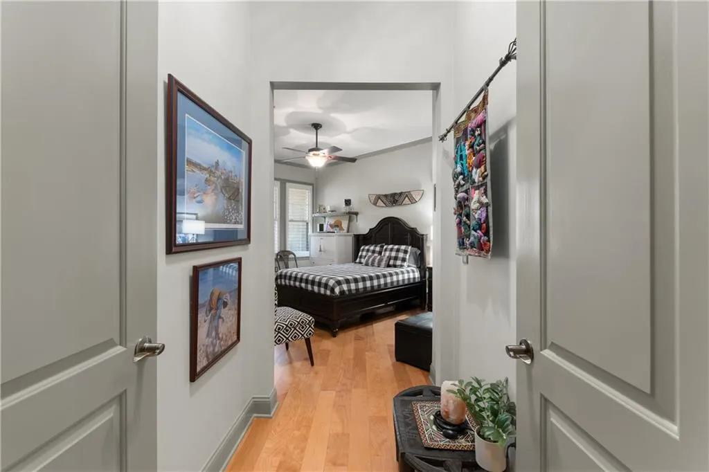 Bedroom with light wood-type flooring, ornamental molding, and a ceiling fan
