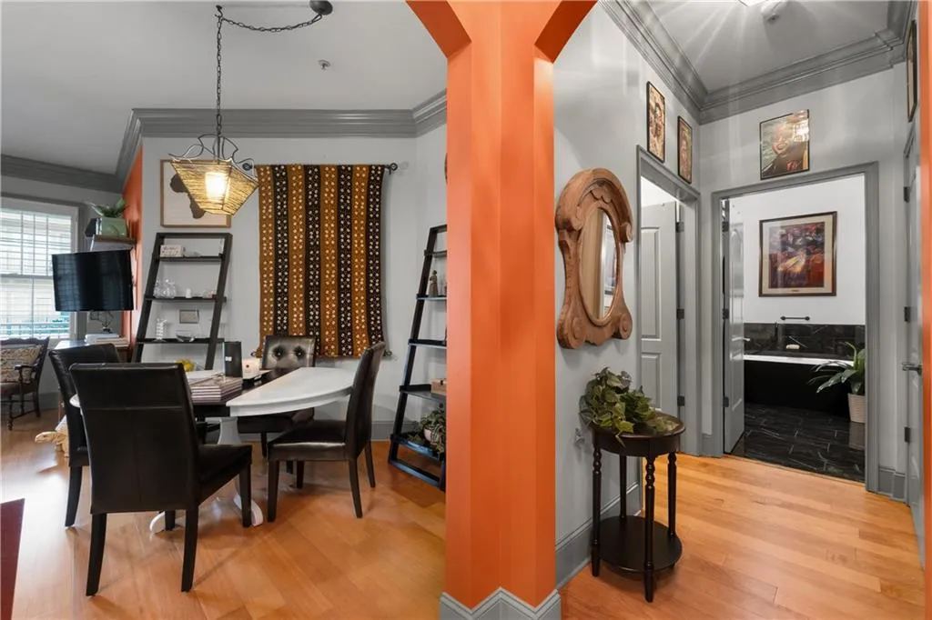 Dining area with ornamental molding, light wood finished floors, and arched walkways