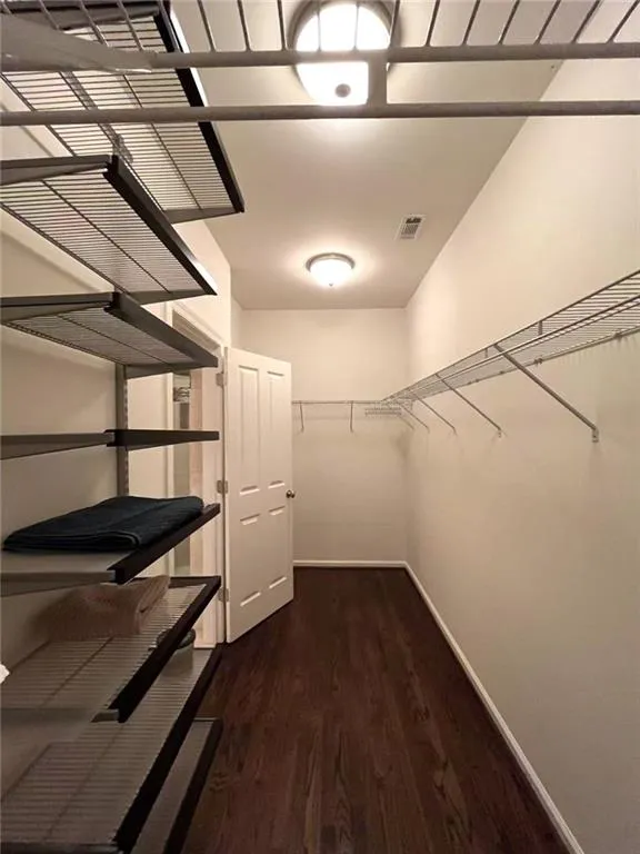 3rd level primary bedroom featuring ornamental molding, a tray ceiling, hardwood  floors, and ceiling fan