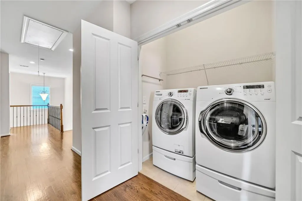 Laundry room featuring attic access, wood finished floors, washing machine and dryer, and recessed lighting