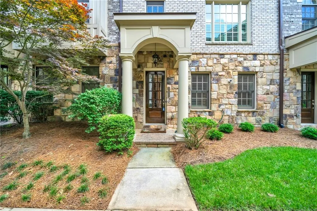 Property entrance featuring stone siding and brick siding