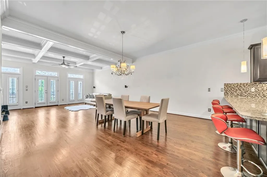 Dining room with coffered ceiling, ceiling fan, beam ceiling, light wood-style floors, and a chandelier
