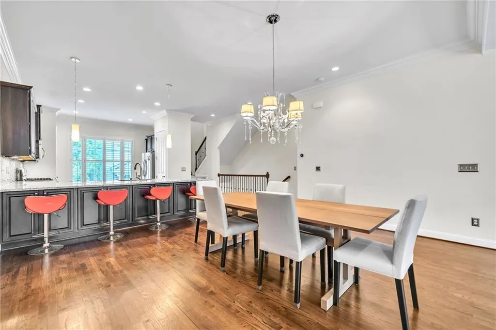 Dining space featuring ornamental molding, dark wood-style flooring, recessed lighting, and a chandelier