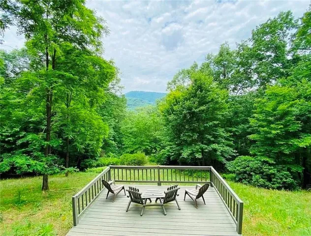 Expansive wood deck featuring a protective railing system and serene mountain scenery