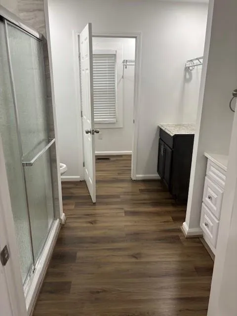 Bathroom with vanity, a shower stall, and wood finished floors