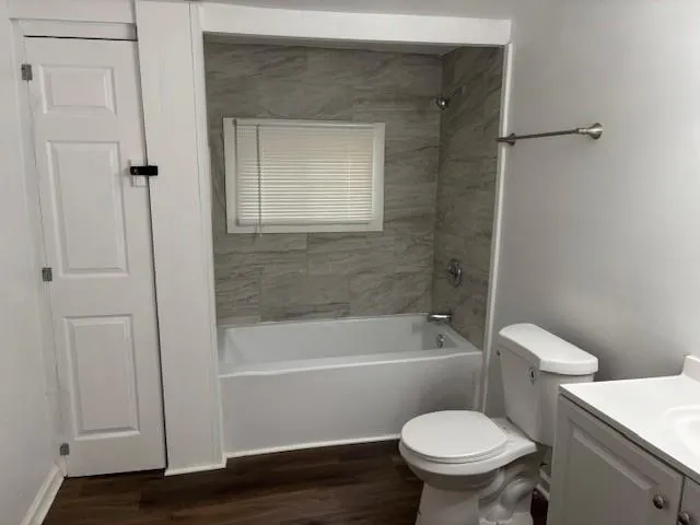 Full bathroom with vanity, shower / bath combination, and wood finished floors