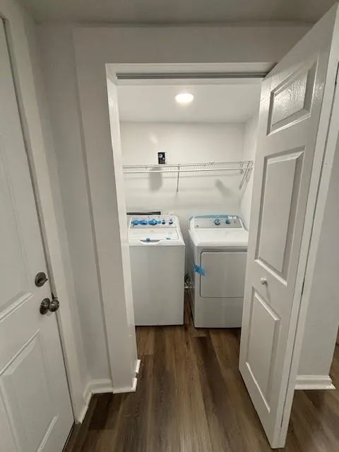Laundry area featuring washer and dryer and dark wood finished floors