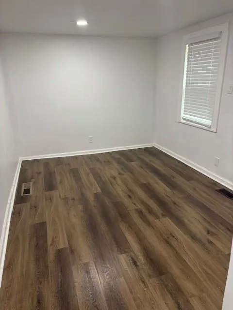 Spare room with dark wood-type flooring and recessed lighting