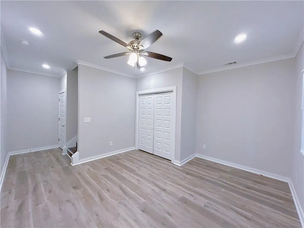 Unfurnished bedroom featuring ceiling fan, crown molding, and light wood-type flooring