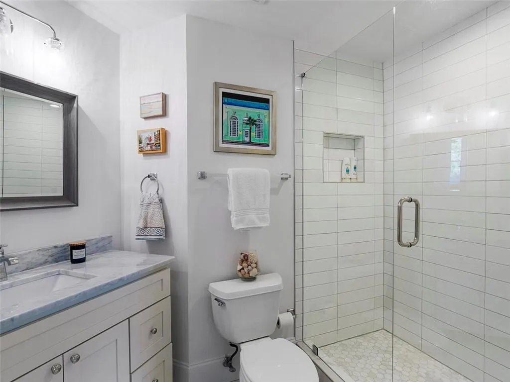 Walk-in shower with clear glass enclosure, subway-style wall tile, and a built-in shower niche