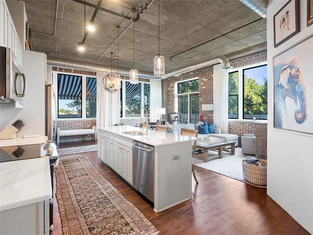 Modern kitchen island with integrated sink, stainless steel appliances, and white cabinetry