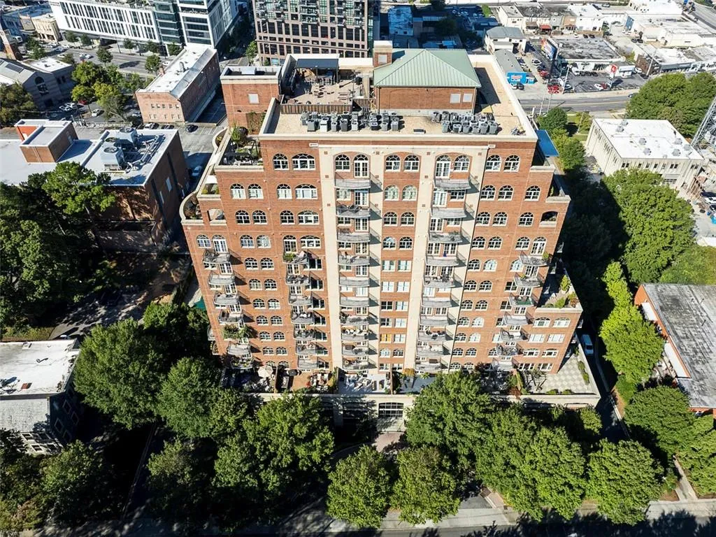 Multi-story building featuring a brick facade, arched windows, and multiple balconies