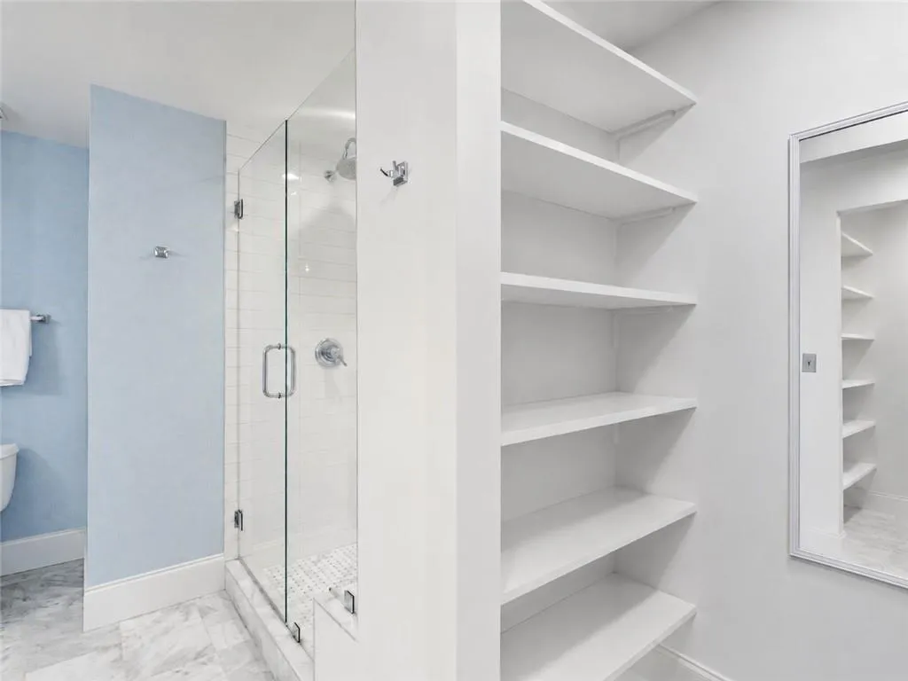 Glass-enclosed shower with white subway tile, mosaic tile shower floor, and chrome fixtures