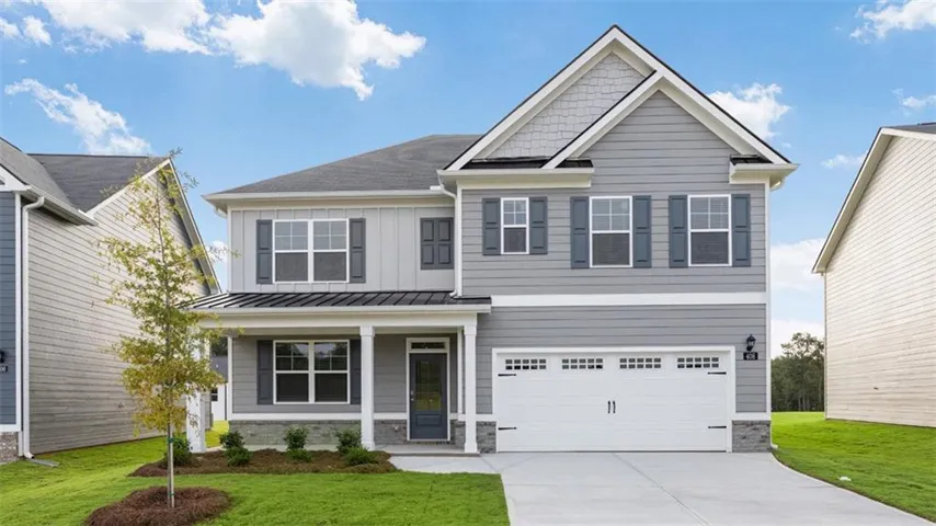 Two-story residence featuring light gray siding, white trim, a covered front porch, and an attached two-car garage