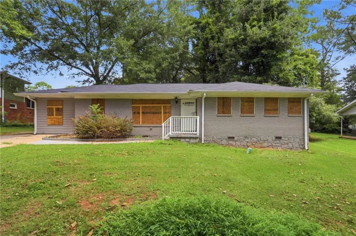 Ranch-style residence featuring a gray painted brick and siding exterior, dark shingle roof, and a front porch with white railings