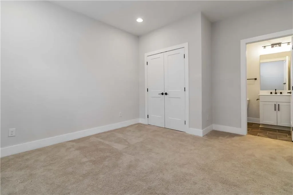 Unfurnished bedroom with carpet flooring, recessed lighting, a closet, and ensuite bathroom