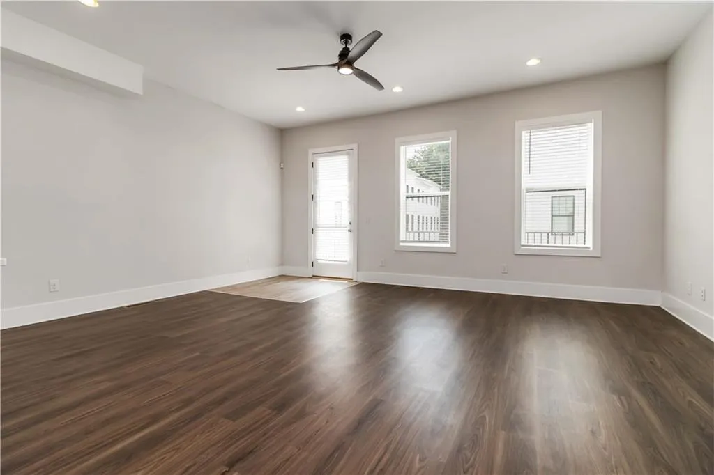 Empty room featuring ceiling fan, dark wood finished floors, and recessed lighting