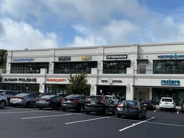View of commercial property featuring uncovered parking