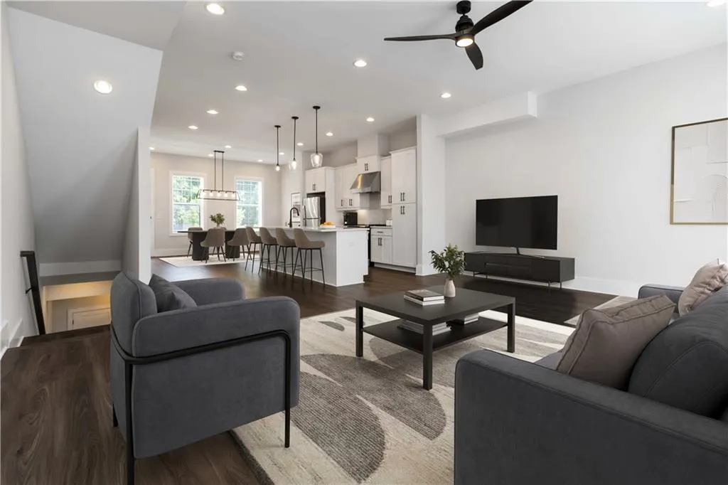 Living area featuring dark wood finished floors, a ceiling fan, and recessed lighting