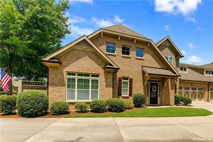 Brick exterior with gabled roof lines, prominent entryway, and attached garage with multiple bays
