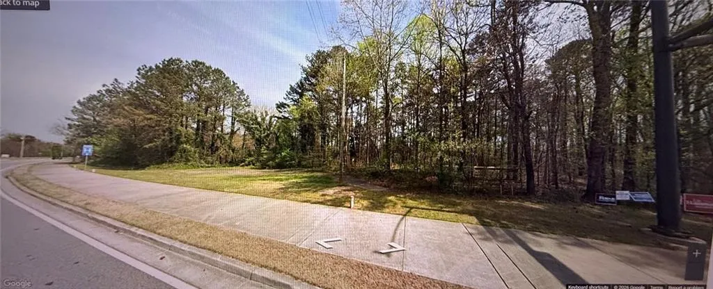 View of asphalt road featuring sidewalks and curbs