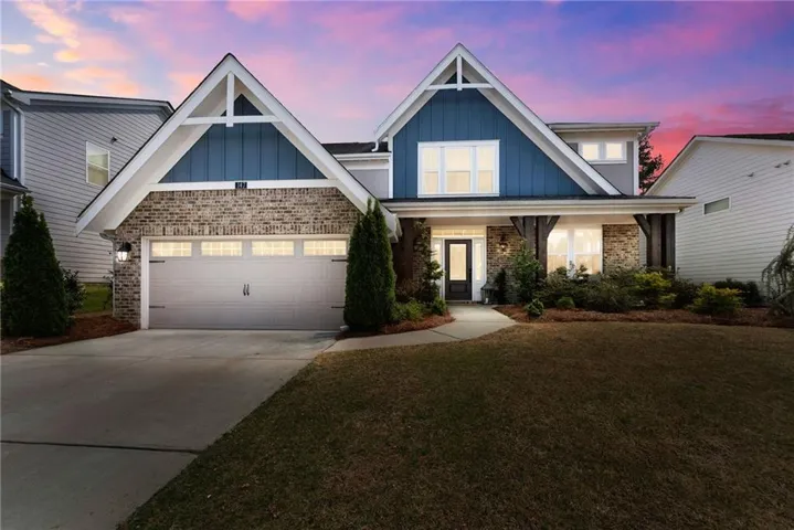 Craftsman inspired home with brick siding, concrete driveway, a lawn, a porch, and a garage