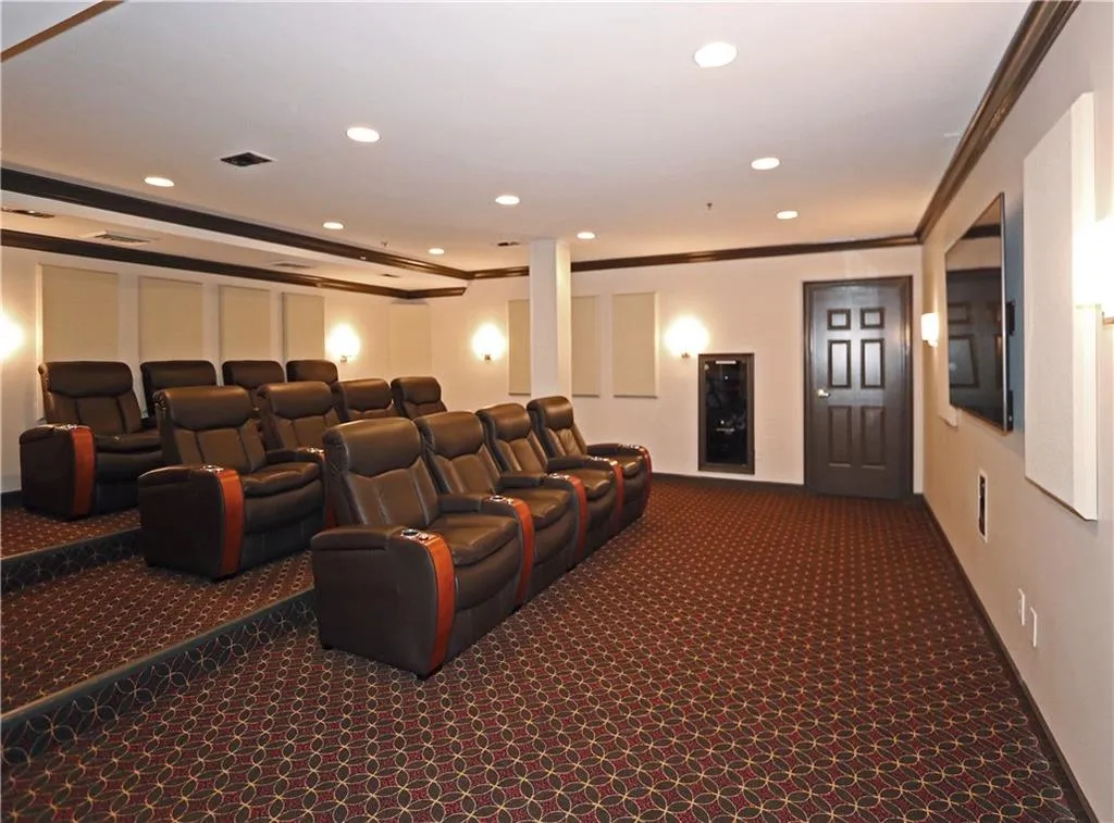 Cinema with carpet flooring, ornamental molding, and recessed lighting