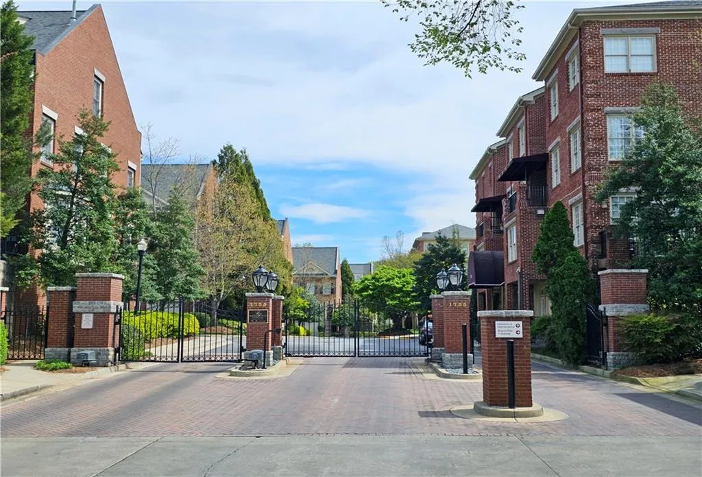 View of street with curbs, street lighting, a gate, a gated entry, and sidewalks