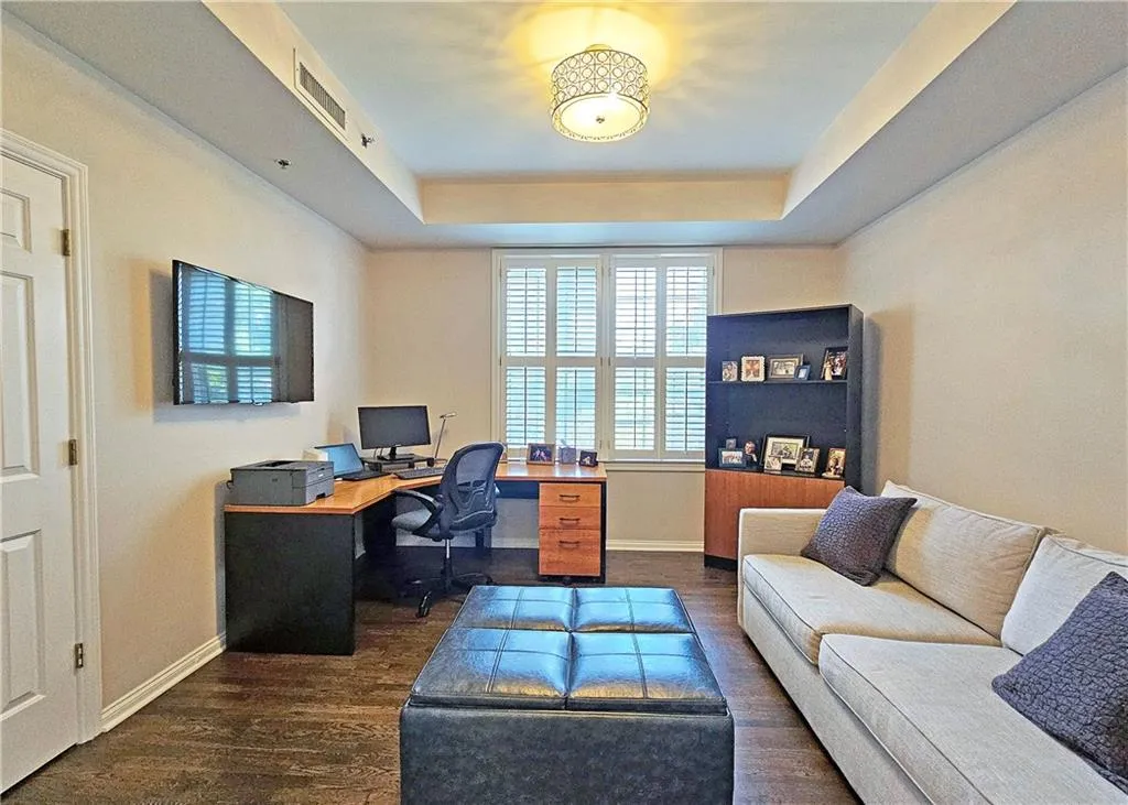 Office area featuring dark wood-type flooring and a tray ceiling