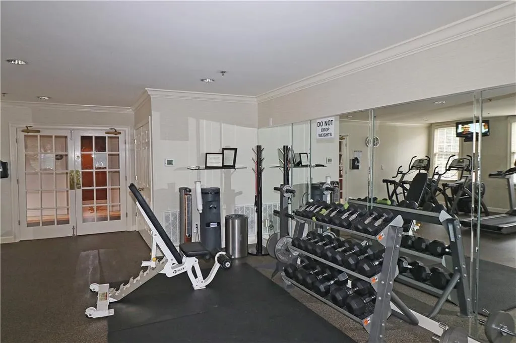 Workout area featuring ornamental molding and french doors