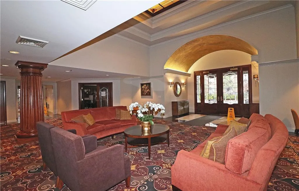 Living area featuring decorative columns, ornamental molding, and recessed lighting