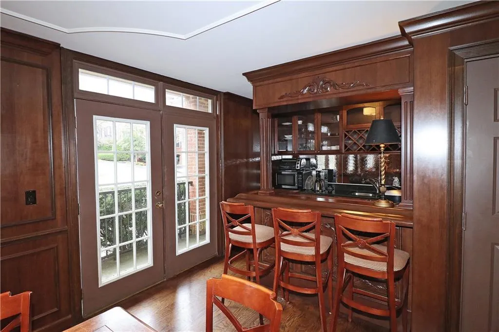 Indoor bar with french doors, wood finished floors, and stainless steel microwave