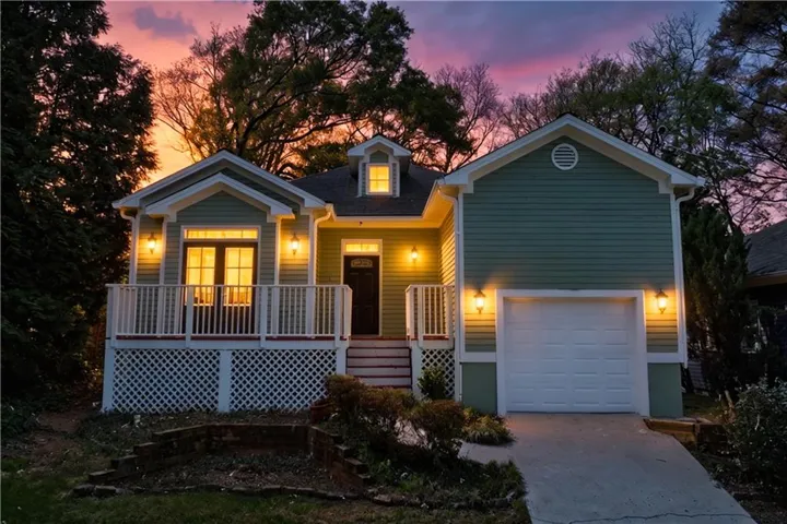 View of front of home featuring a porch, a garage, and concrete driveway