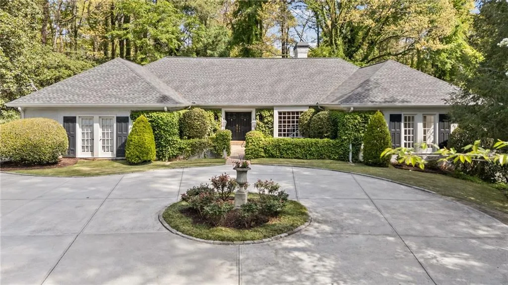 Single story home with french doors, roof with shingles, and curved driveway