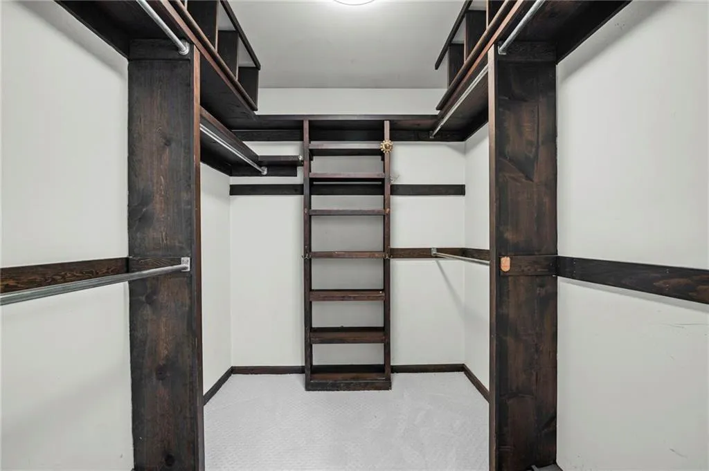 Walk in Primary closet with light carpet
